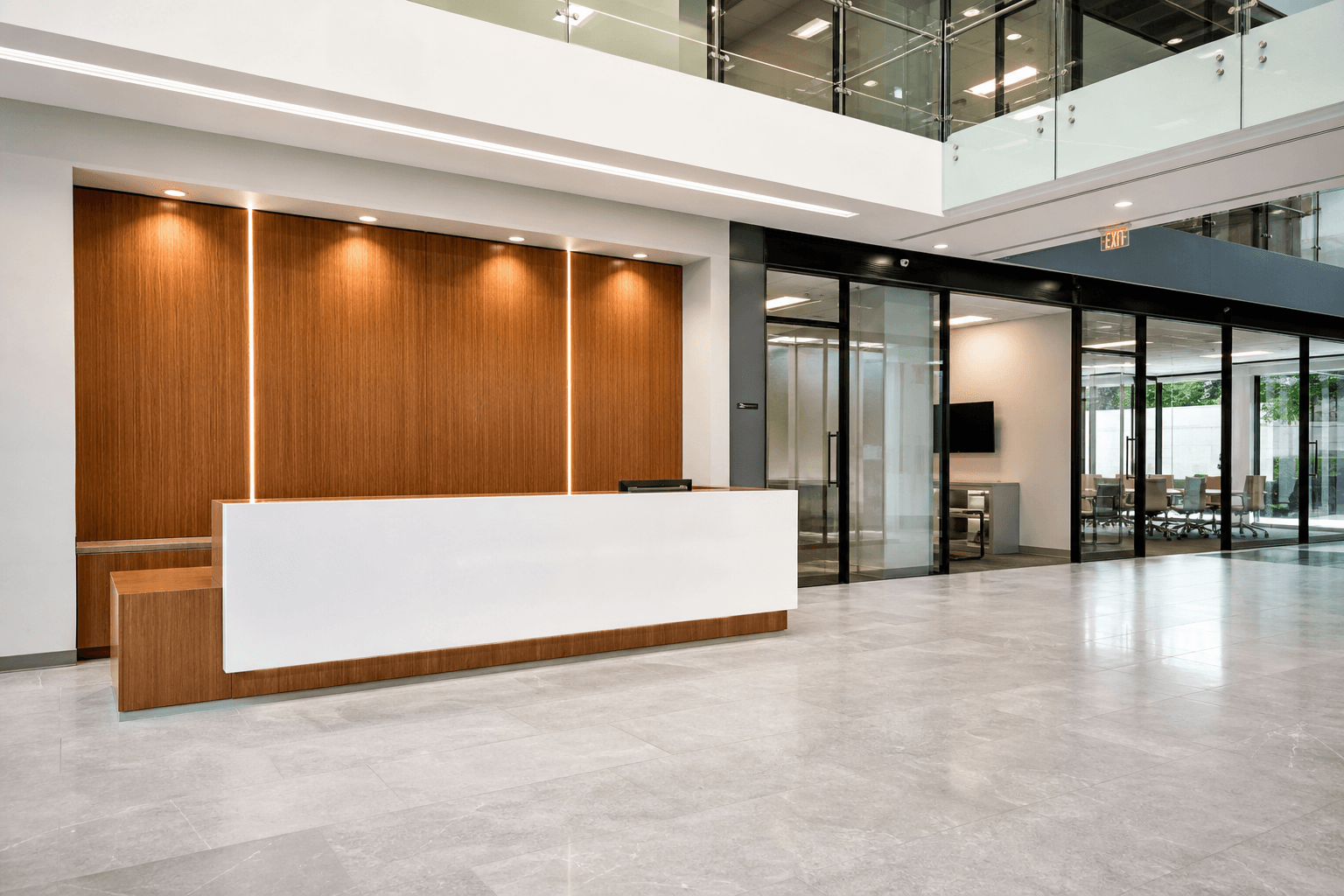 Wide empty modern commercial lobby with reception desk, glass, and polished floor; interior cleaning context; no people